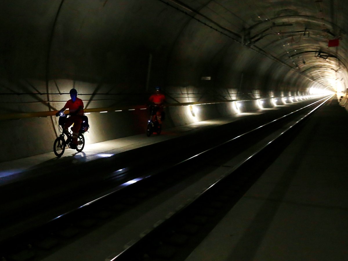 Работники тоннеля используют складные велосипеды для передвижения по строительным площадкам.
